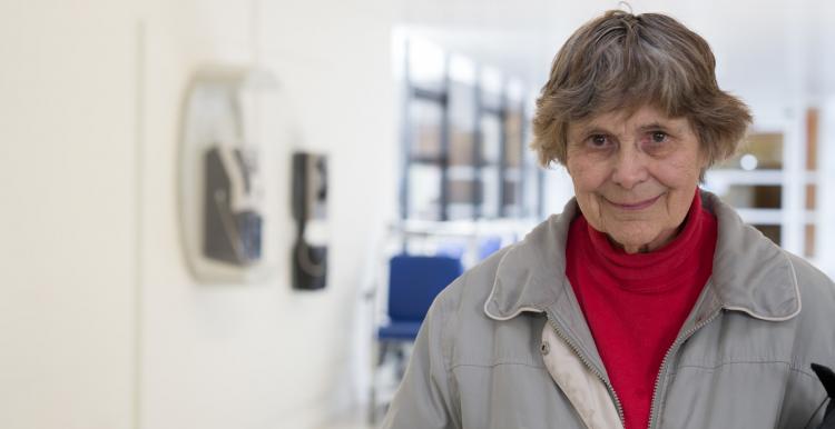 Elderly lady standing in a hospital corridor